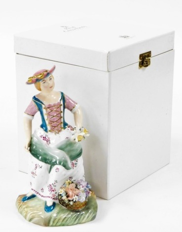 A Royal Crown Derby boxed figure of The Flower Seller, in flowing dress holding daffodils, signed J Bryan, LVII, 20cm high, boxed with certificate.