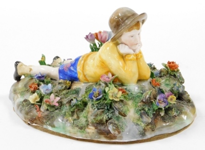 A Royal Staffordshire figure group, of a boy lying in flower garden, modelled by Bagley, with green stamp to underside and partially rubbed label, 24cm wide.