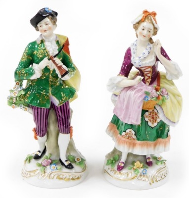 Two Continental porcelain figures, depicting a lady and gentleman each elaborately dressed, with encrusted flowers, with gold anchor mark to reverse, 24cm high.