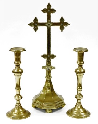 A large Victorian jewelled brass altar cross, inset with blue stones, 62cm high, and a pair of associated altar candlesticks, 37cm high. (3)