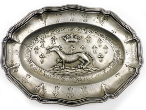 A continental pewter platter, the design embossed with greyhound and crown above crested symbol, on a flared oval rim, 28cm wide.