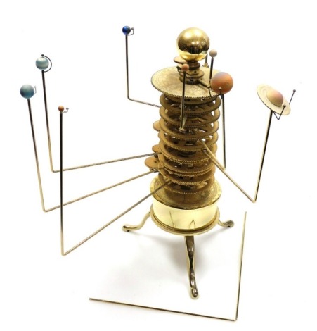 A rotating solar system clockwork orrey model, depicting the nine planets, on a brass tripod base, 38cm high.