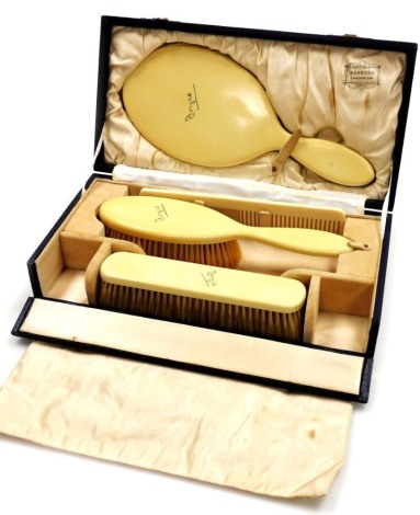 A Harrods of London ivorine dressing table set, comprising mirror, two brushes and a comb, each inscribed Joyce, in a fitted case.