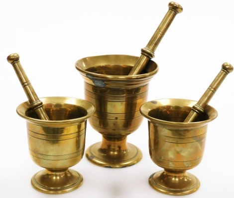 A set of three antique bronze pestles and mortars, one 15cm high and two 11cm high.