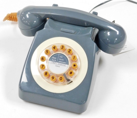 A push dial button modern telephone, in the vintage style, grey with orange buttons.