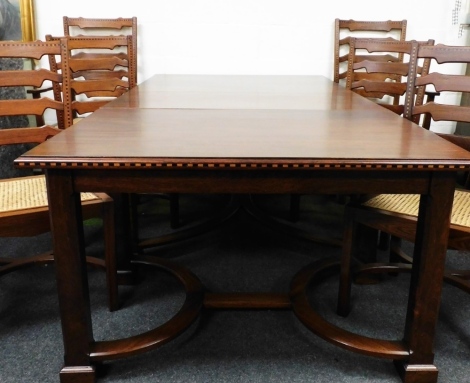 A mahogany and chequer banded dining table, in three sections on square tapering legs with flat stretchers and eight matching chairs, two carvers, 71cm high, 224cm wide, 125cm deep.