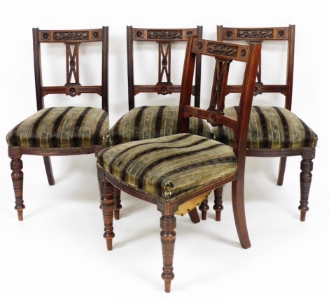A set of four Edwardian walnut dining chairs, the backs with floral rosettes and leaves and berries, on a striped green material base, 87cm high, 46cm wide.