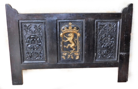A black painted headboard, with three panel decoration, the central panel with lion motif in gilt painted decoration, the outer panels with floral rosettes, 92cm high, 137cm wide.