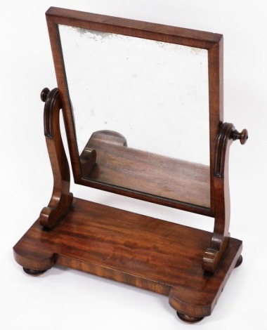 A Victorian mahogany framed dressing table mirror, the rectangular mirror plate on two supports, on bun feet, 62cm high, 47cm wide, 24cm deep.