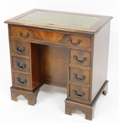 A mahogany kneehole desk, the rectangular top with green leather inset above one long drawer with three drawer pedestals, 74cm high, 76cm wide, 50cm deep.