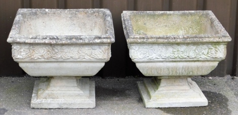 Two reconstituted stone rectangular garden planters, each with a ribbed border above rose detail on pedestal base, 44cm high, 52cm square.