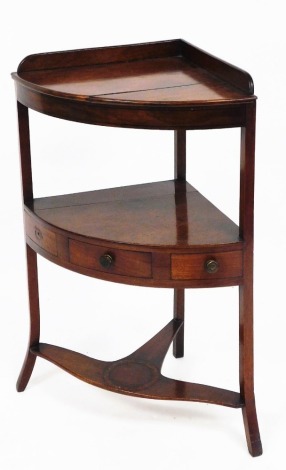 A George III mahogany corner wash stand, of three tiers, the central section with drawer, 84cm high, 58cm wide, 41cm deep.