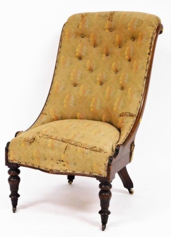 A spoon back nursing chair, with oak frame and button back floral upholstery, with ribbon borders on castors, 102cm high, 55cm wide, 50cm deep.