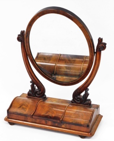 A Victorian flame mahogany dressing table mirror, with oval plate, on scroll supports, with three lift lid section, on bun feet, 92cm high, 62cm wide, 32cm deep.