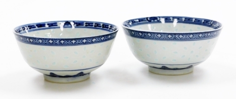 Two Chinese blue and white rice bowls, with leaf and diaper borders, the bodies with translucent rice grain design, maker's mark to base, 11.5cm diameter. (2)