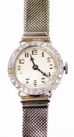 A 1930/40s diamond set ladies cocktail watch, the small circular cream dial with blue hands and outer tiny diamond set border in a white metal casing, possibly platinum, on a weaved design bracelet, the watch head 2cm wide, 19.8g all in.