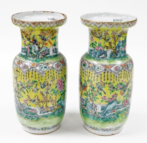 A pair of 19thC Chinese porcelain baluster vases, each heavily decorated with birds and flowers, on a famille jeune ground, 36cm high. (2)