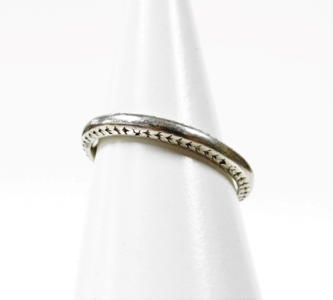 A platinum wedding band, of etched design to the sides but worn and mis-shapen, ring size K, 4.4g all in, boxed.