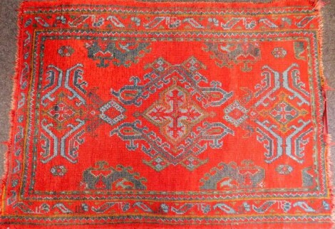 An English tufted wool rug of Turkish design, red ground, 165cm x 125cm.