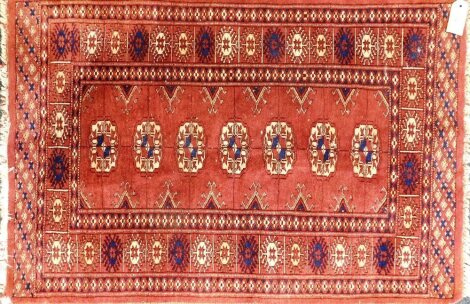 A Bokhara design rug with red ground, 64cm x 91cm.