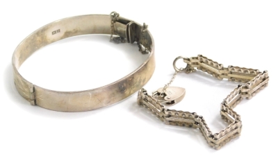 A silver gate bracelet and bangle, the hinged bangle with half etched floral design, with safety chain, and a three row silver gate bracelet, with heart padlock, 32.7g all in. (2)