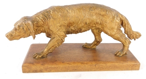 A gilt spelter figure of a hound, on an oak base, 38cm wide.