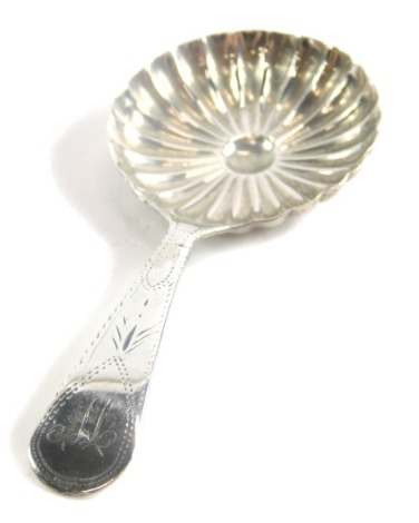 A George III silver caddy spoon, by John Turner, the bowl decorated with a radiating pattern, with a bright cut decorated handle engraved with a W, Birmingham 1799, 8cm long.