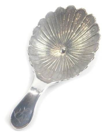 A George III silver caddy spoon, by William Pugh, with a floral shaped bowl and plain handle, engraved with the letter P, Birmingham 1805, 7cm long.