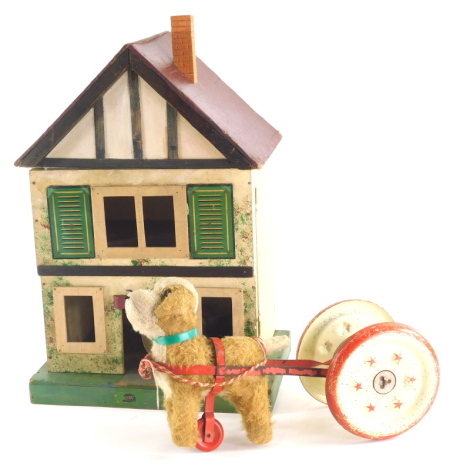 Various bygone child's toys, a pull along dog and bell figure, 30cm wide, and a mock Tudor child's doll house, of small proportion with hinged front opening, a Noddy egg cup and an articulated Scandinavian carved nodding figure, (4).