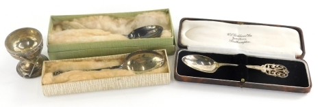 Three cased silver teaspoons, and a George golf ball hole in one egg cup, Birmingham 1929, 5cm high.