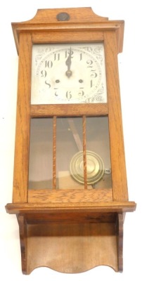 An early to mid 20thC oak wall clock, with silvered dial, 80cm high.