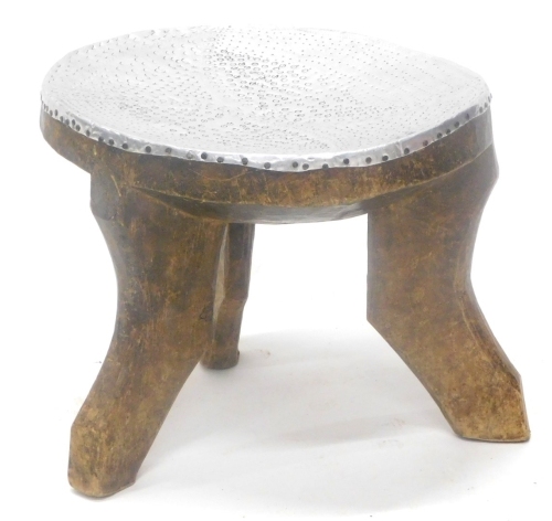 A tribal art African stool, with hammered aluminum top, possibly Ashanti, 36cm wide.