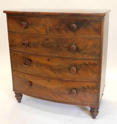 A Victorian mahogany bow fronted chest of drawers, with two short and three long drawers, each with turned wood handles on turned feet, 105cm wide.