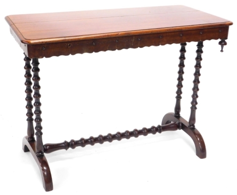 A Victorian mahogany library table, the rectangular top with a moulded edge and a crenellated frieze with drop finial, on twin bobbin turned supports with central stretcher and splayed feet, (AF), 67cm high, 91cm wide, 45cm deep.