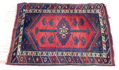 A Persian rug, with a pole medallion on a red ground with one wide and one narrow border.