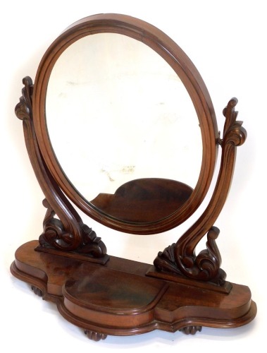 A Victorian mahogany dressing table mirror, the over plate on pierced carved supports, with shaped base with a central hinged trinket compartment, on lobed feet, 65cm wide.