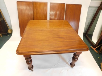 A Victorian mahogany extending dining table, the rectangular top with a moulded edge on turned tapering legs on brass castors, four loose leaves, 72cm high, the top 122cm x 336cm. - 2