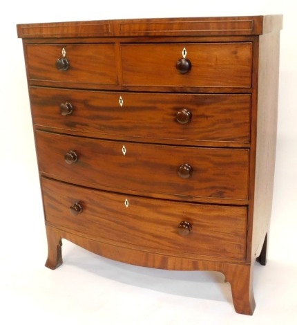 A Victorian mahogany bow fronted chest of drawers, with panel feet, above two short and three long drawers, each with turned wood handles, on splayed legs, 117cm high, 104cm wide.