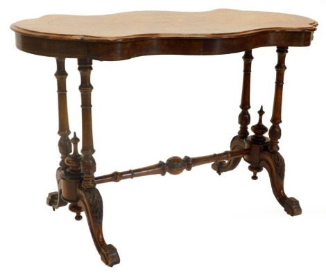 A Victorian figured walnut centre table, the shaped top with a central marquetry decoration of scrolls and leaves, on twin end supports, with stretcher and splayed legs with ceramic castors, 106cm wide.