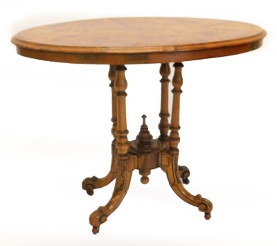 A Victorian walnut occasional table, the circular quarter veneered top with inlaid border on four turned supports with carved and splayed legs and ceramic castors, 71cm high, 90cm wide.