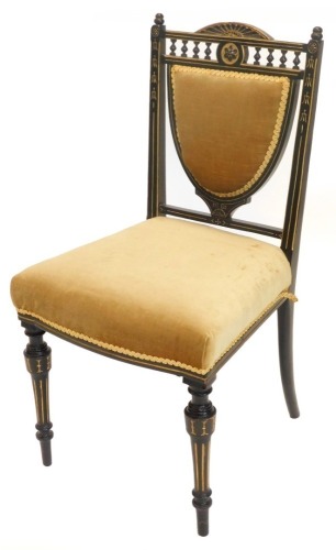 A Victorian ebonised and parcel gilt aesthetic movement side chair, with a padded back and seat on turned fluted legs.