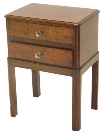 An early 20thC mahogany work or bedside table, with a moulded top above two drawers, each with moulded glass handles on rounded plain legs, 36cm wide.