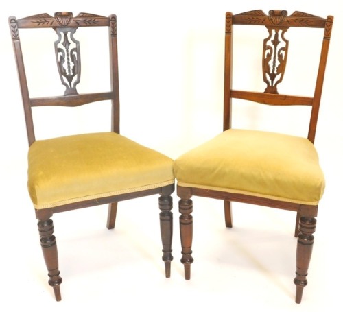 A pair of late 19thC walnut side chairs, each with a pierced splat and a padded seat on turned tapering legs.