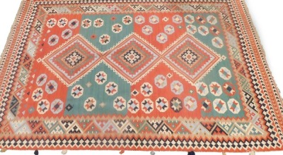 A Kilim rug, with a geometric design in green, blue, navy cream, etc., 199cm x 294cm.