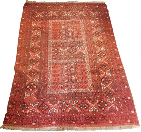 A Balouch type rug, with a design of medallions, on a red ground with multiple borders, 243cm x 171cm.