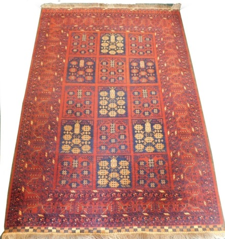 A Balouch type rug, with a design of medallions, in navy and cream on a red ground with multiple borders, 207cm x 143cm.