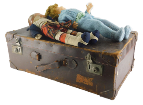 An early 20thC vintage pressed leather travel case, containing dolls, to include one in Highland dress, with fixed eyes, open mouth and no teeth, 48cm high, etc. (a quantity)