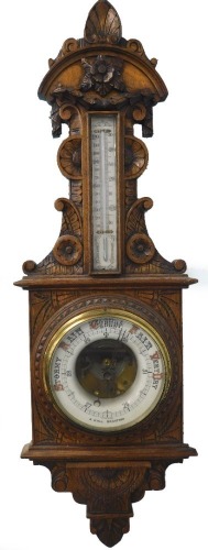 A late 19th/early 20thC carved oak barometer, with thermometer, stamped J Hall Bradford, 96cm long.