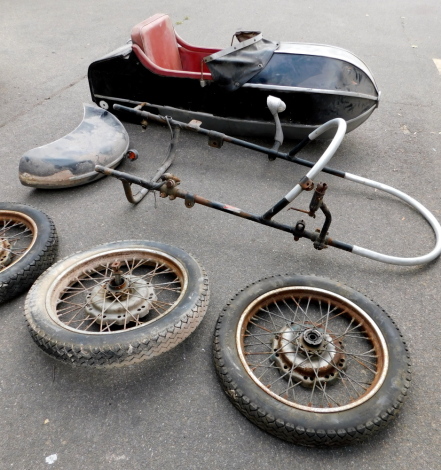 A motorcycle sidecar, together with three wheels, two for the bike, one for the sidecar, and a mudguard.