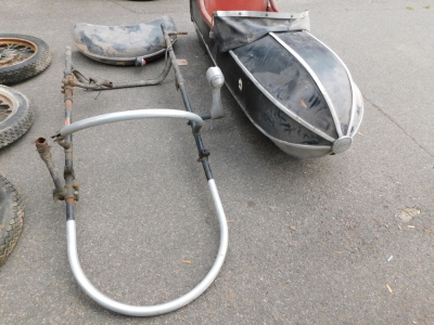 A motorcycle sidecar, together with three wheels, two for the bike, one for the sidecar, and a mudguard. - 2